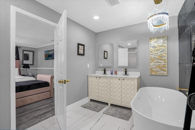 bathroom featuring crown molding, a tub to relax in, a chandelier, and vanity