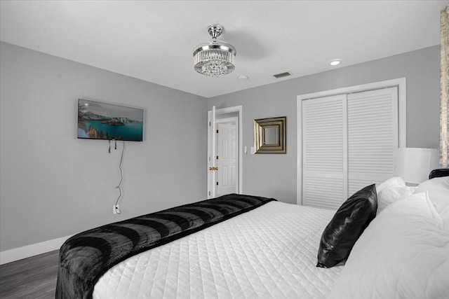 bedroom with dark hardwood / wood-style flooring and a closet