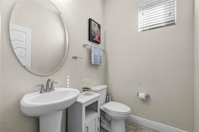 bathroom featuring toilet, tile patterned flooring, and sink