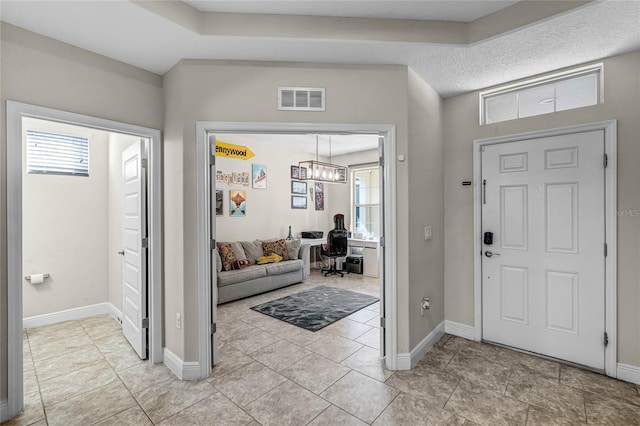 entryway featuring an inviting chandelier and light tile patterned floors