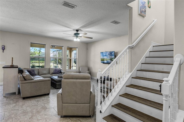 living room featuring a textured ceiling and ceiling fan