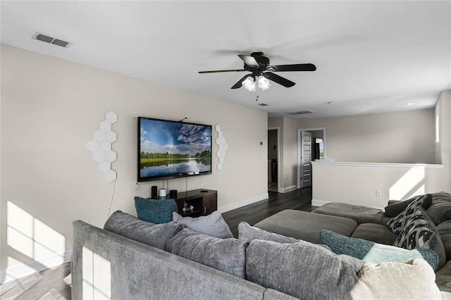 living room featuring ceiling fan and dark wood-type flooring