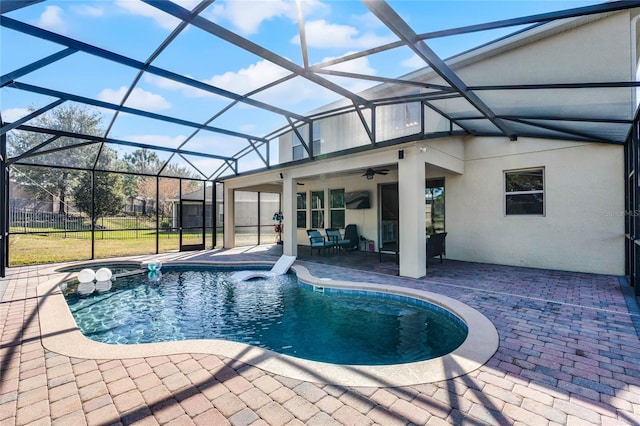 view of pool with a lanai, a patio area, ceiling fan, and a yard