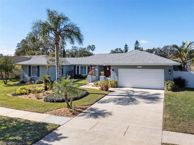 ranch-style house featuring a garage, a front yard, concrete driveway, and stucco siding