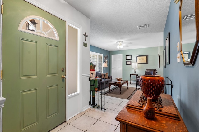 entrance foyer with light tile patterned floors, a textured ceiling, visible vents, and a ceiling fan