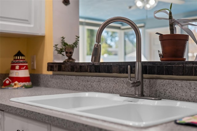 interior details featuring light countertops, a sink, and white cabinetry