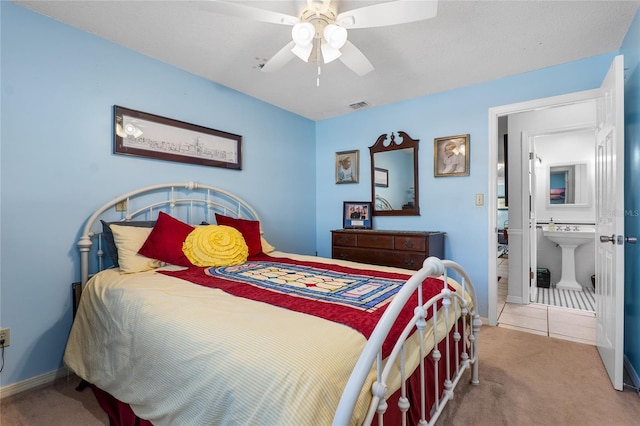 tiled bedroom featuring ceiling fan, a sink, visible vents, baseboards, and carpet