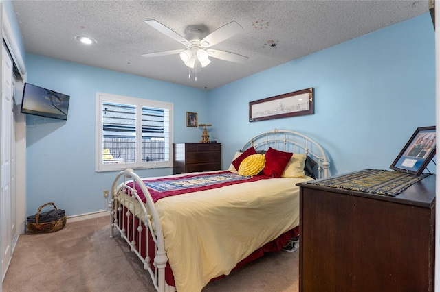 bedroom featuring a textured ceiling, ceiling fan, carpet flooring, and baseboards