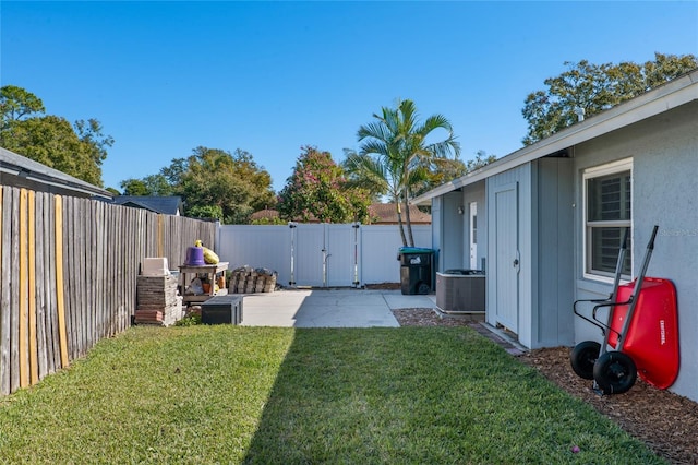 view of yard with a patio area, a fenced backyard, a gate, and cooling unit