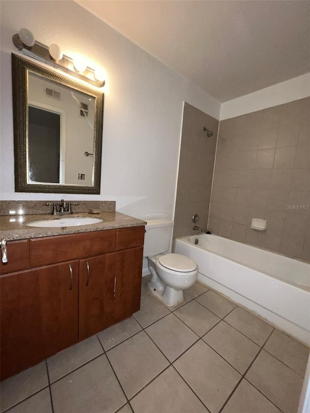 full bathroom with tile patterned floors, toilet, vanity, and tiled shower / bath