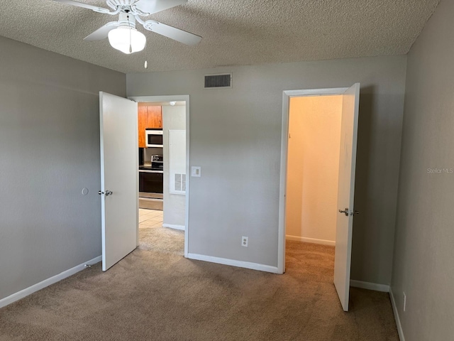 11538 Westwood Blvd Unit 226, Orlando, FL 32821 - unfurnished bedroom with light colored carpet, a textured ceiling, and a ceiling fan