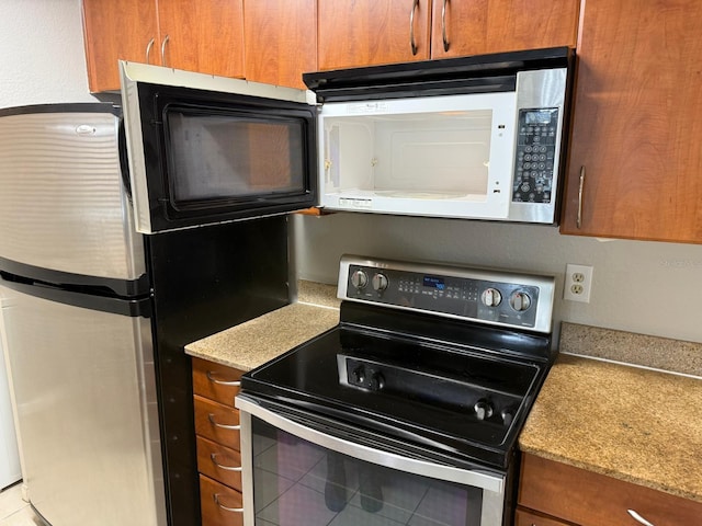 11538 Westwood Blvd Unit 226, Orlando, FL 32821 - kitchen with appliances with stainless steel finishes, brown cabinetry, and light countertops