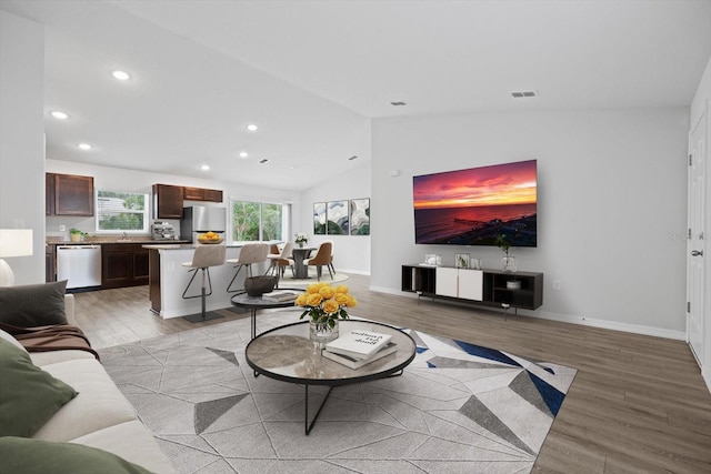 living room featuring lofted ceiling and light wood-type flooring