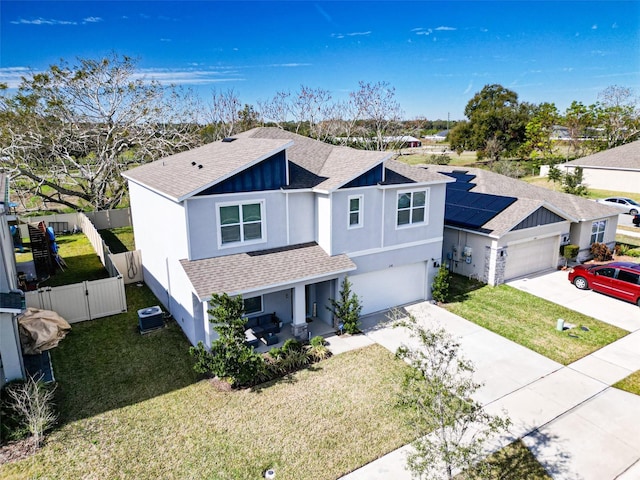 view of front of house featuring a garage, a front yard, and cooling unit