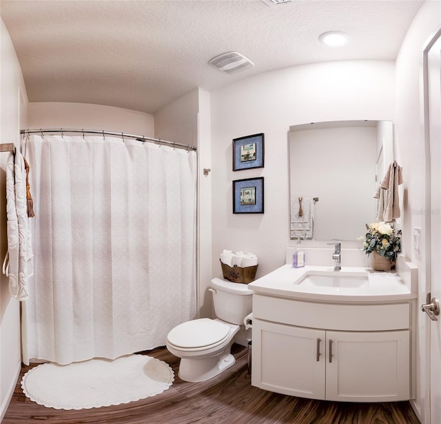 bathroom with vanity, hardwood / wood-style floors, a textured ceiling, and toilet