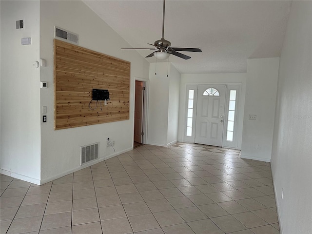 tiled foyer with ceiling fan and lofted ceiling