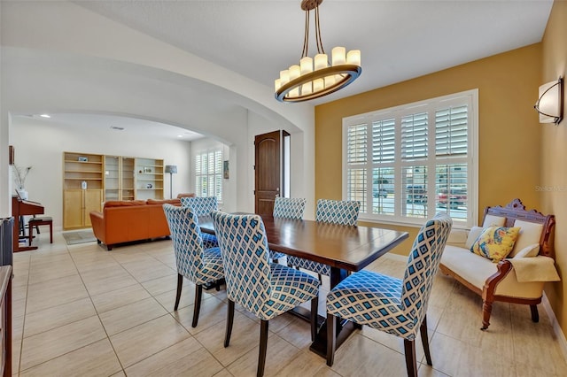 tiled dining area featuring a chandelier