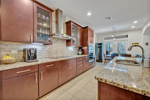 kitchen with sink, backsplash, hanging light fixtures, black electric cooktop, and wall chimney exhaust hood