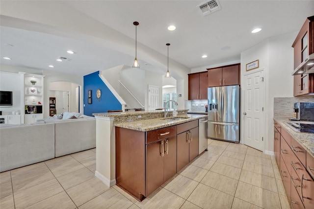 kitchen with decorative light fixtures, tasteful backsplash, sink, light tile patterned floors, and stainless steel appliances