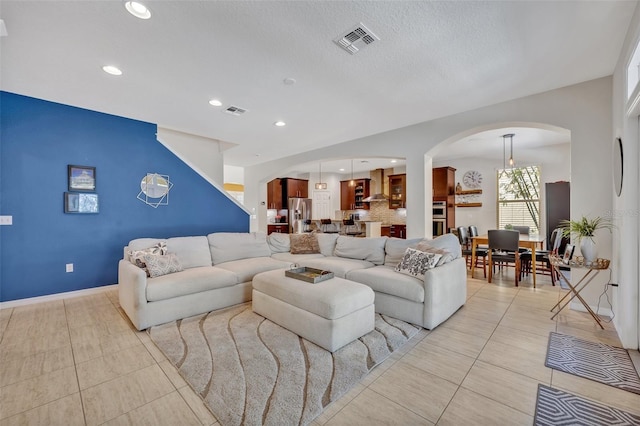 living room featuring a textured ceiling and light tile patterned flooring