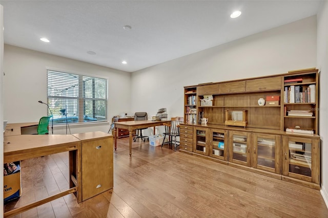 home office with light hardwood / wood-style flooring