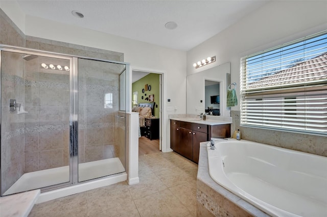 bathroom featuring independent shower and bath, vanity, and tile patterned floors