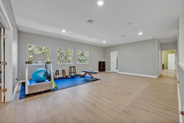 exercise room with light hardwood / wood-style flooring