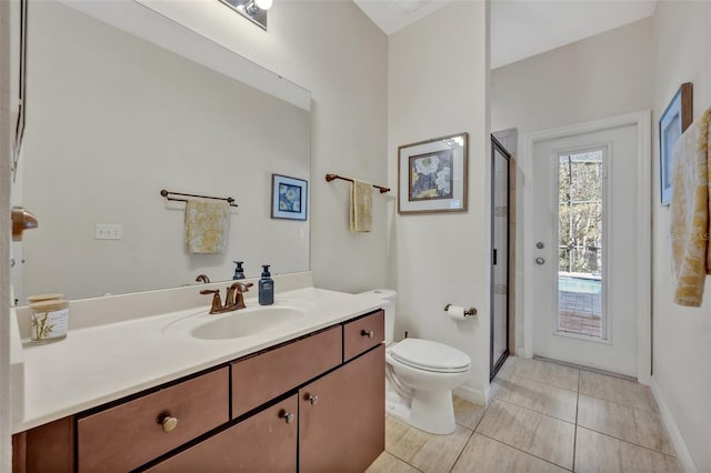 bathroom featuring a shower with door, vanity, tile patterned flooring, and toilet