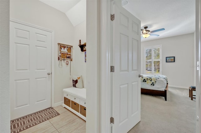 hallway with lofted ceiling and light carpet