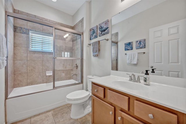 full bathroom with bath / shower combo with glass door, tile patterned floors, vanity, and toilet