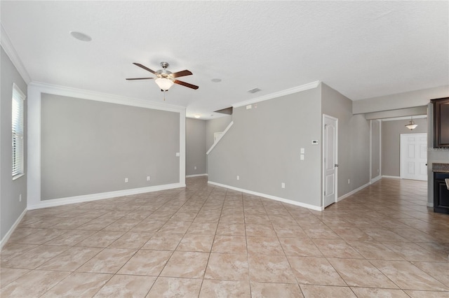 spare room with a textured ceiling, ceiling fan, crown molding, and light tile patterned flooring