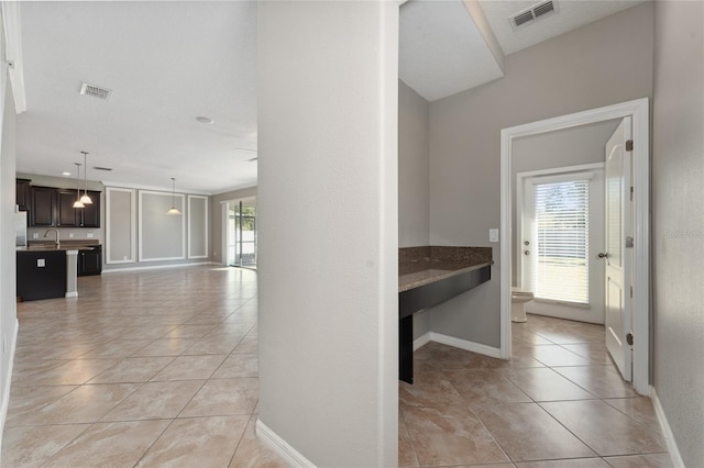 hallway with light tile patterned floors and sink