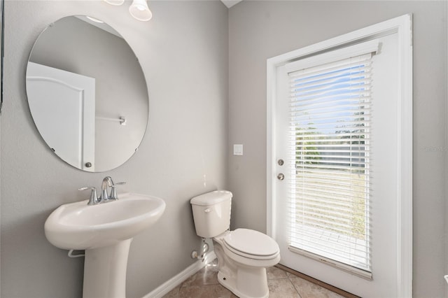 bathroom with tile patterned floors, toilet, and a wealth of natural light