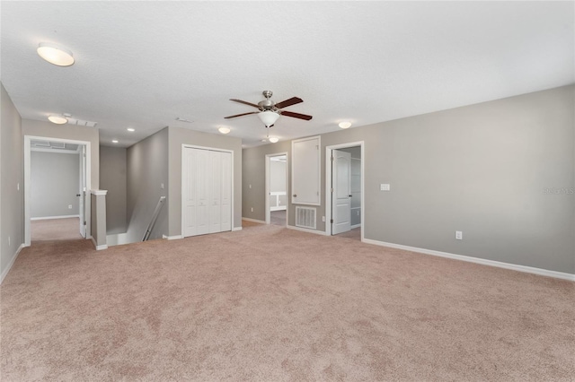 carpeted spare room featuring a textured ceiling and ceiling fan