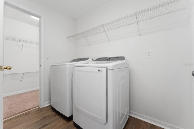 clothes washing area featuring dark hardwood / wood-style flooring and washer and dryer