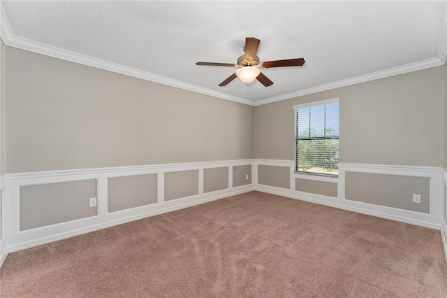 carpeted spare room featuring ceiling fan and ornamental molding