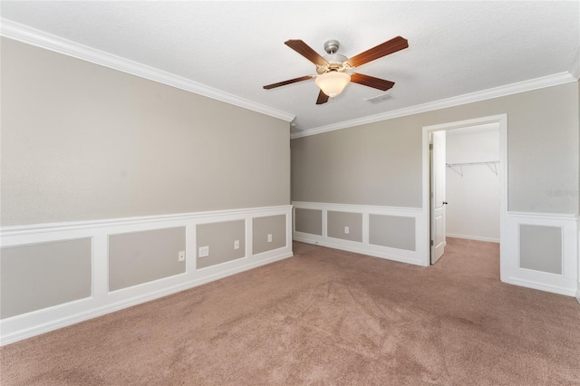 carpeted spare room with ceiling fan, a textured ceiling, and ornamental molding