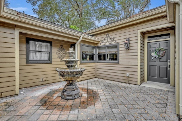 view of exterior entry with a patio