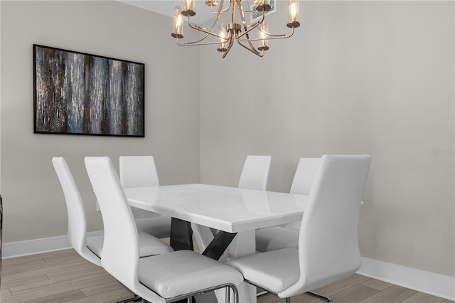 dining room with a chandelier and light wood-type flooring