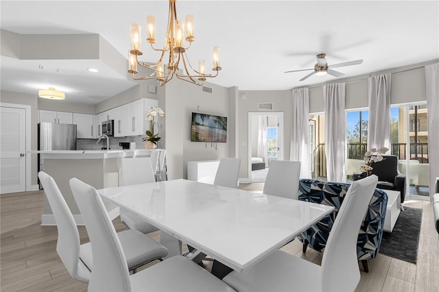 dining room with ceiling fan with notable chandelier