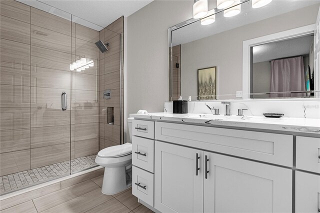 bathroom with vanity, toilet, and walk in shower