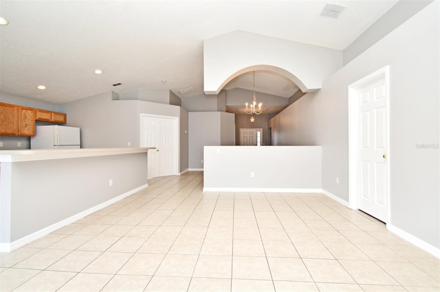 unfurnished living room with light tile patterned flooring, a chandelier, and lofted ceiling