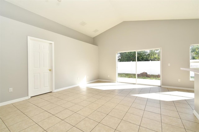 empty room with light tile patterned floors and vaulted ceiling