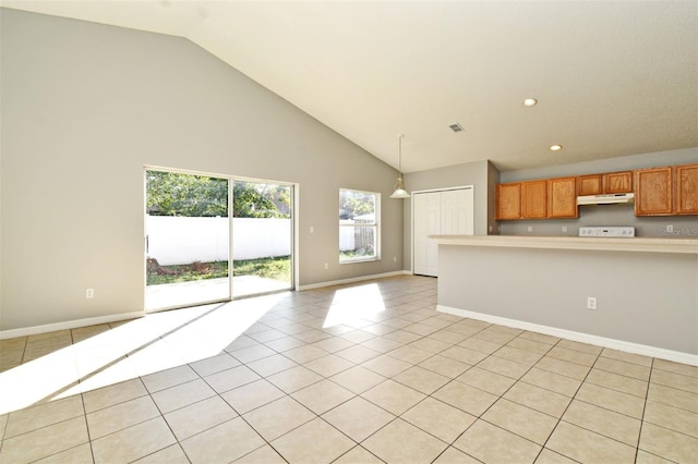 kitchen featuring light tile patterned floors, decorative light fixtures, and high vaulted ceiling