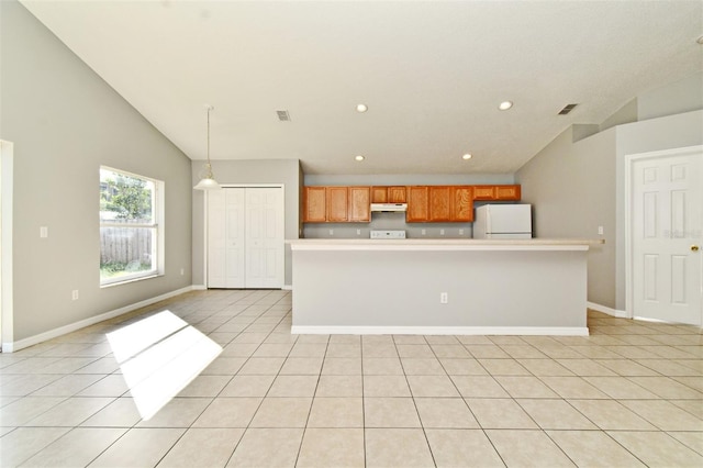 kitchen featuring a center island, light tile patterned flooring, lofted ceiling, and white refrigerator