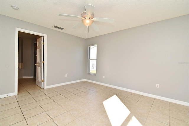 tiled spare room with ceiling fan and a textured ceiling