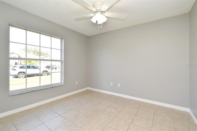 tiled spare room with a textured ceiling and ceiling fan