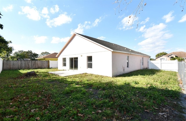 back of house featuring a patio area and a lawn