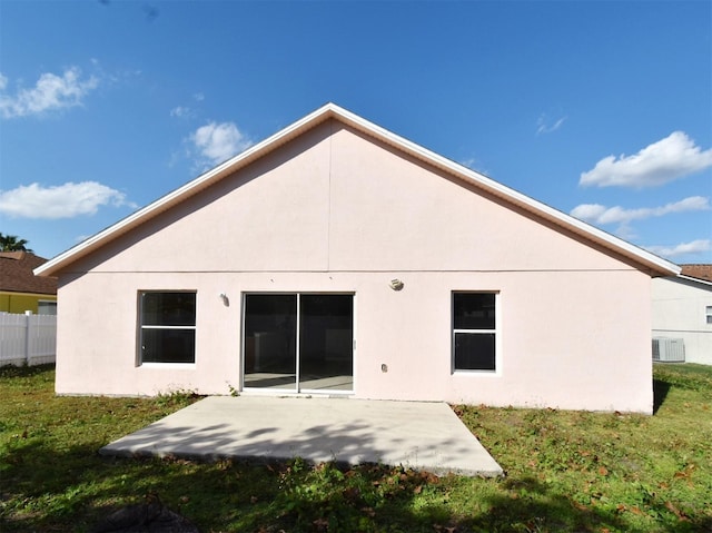 back of house with central air condition unit, a patio area, and a lawn