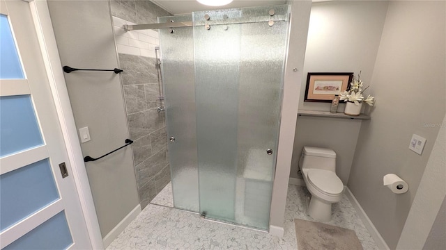 bathroom with a shower with shower door and toilet